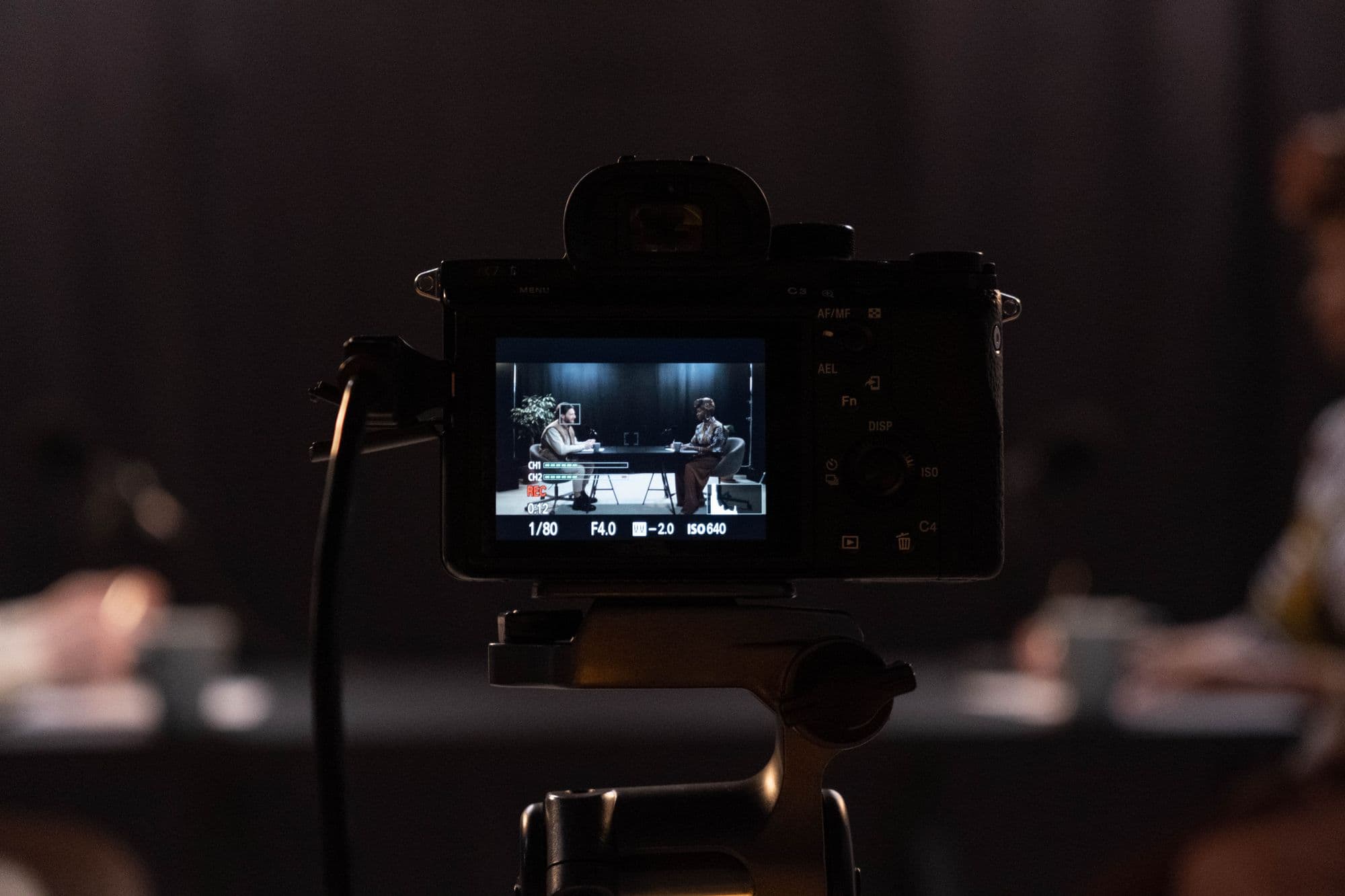 A camera filming a conversation between two people.